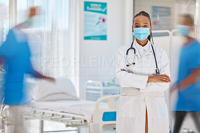 Buy stock photo Portrait, covid and healthcare with a doctor black woman arms crossed in a busy hospital for service. Trust, medical and mask with a female medicine professional working in a clinic for health