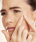 Face, hands and pimple with a woman checking or examining her skin for acne problems in studio. Facial, fingers and breakout with an attractive young female indoor to squeeze or pop a blackhead