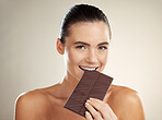 Beauty portrait, eating and woman with chocolate, junk food or dessert for sugar sweets, candy snack or cheat meal. Cosmetics makeup, skincare and hungry model with cacao product for antioxidants