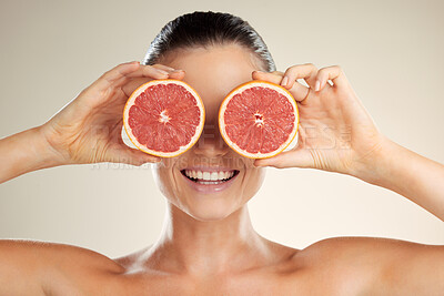 Buy stock photo Beauty, skincare and woman cover grapefruit for natural skin dermatology or cosmetic product. Vitamin c fruit on happy face aesthetic model in studio for sustainable self care for health and wellness