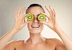 Kiwi fruit, skin care and beauty of a woman with natural dermatology cosmetic product. Healthy glow on face of aesthetic model in studio for sustainable spa facial mask for health and wellness