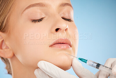 Woman, studio and botox injection for lip filler, beauty and anti-aging skincare process by blue background. Model, facial plastic surgery and syringe needle with doctor, surgeon or cosmetic expert