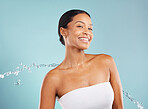 Water splash, black woman and beauty portrait in studio for cleaning cosmetics on blue background. Face of happy female model, shower drops and healthy skincare for body wellness, aesthetic and smile