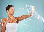 Water splash, hand and woman with skincare, beauty and wellness ready for a shower. Blue background, studio and isolated female model with dermatology, skin glow and cleaning treatment feeling calm