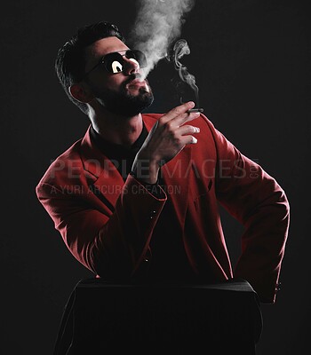 Buy stock photo Fashion, smoke and red with a man model in studio on a dark background wearing a suit for style. Smoking, mafia and edgy with a handsome young male posing on black space holding a cigarette