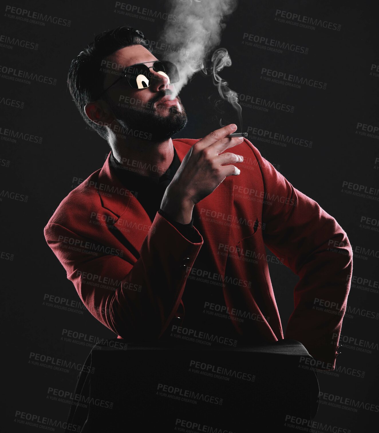 Buy stock photo Fashion, smoke and red with a man model in studio on a dark background wearing a suit for style. Smoking, mafia and edgy with a handsome young male posing on black space holding a cigarette