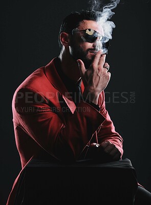 Buy stock photo Fashion, smoking and red with a man model in studio on a dark background wearing a suit for style. Smoke, mafia and edgy with a handsome young male posing on black space holding a cigarette