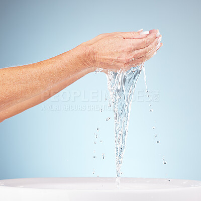 Buy stock photo Senior hands, water and splash for clean hygiene, fresh minerals or wash against a studio background. Hand of elderly holding natural liquid for skin hydration, wellness or skincare in sink or basin