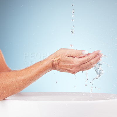 Buy stock photo Senior hands, water and wash for clean hygiene, fresh minerals or splash against a studio background. Hand of elderly holding natural liquid for skin hydration, wellness or skincare in sink or basin
