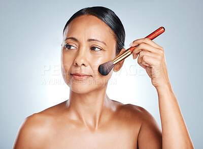 Buy stock photo Cosmetics, senior woman and brush for dermatology, beauty and lady on grey studio background. Makeup tools, mature female and foundation for face, natural care and wellness for smooth and clear skin