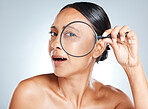Magnifying glass, skincare and mature woman in a studio with a health, wellness and natural face routine. Beauty, cosmetic and portrait of a female with a lens for an anti aging facial treatment.