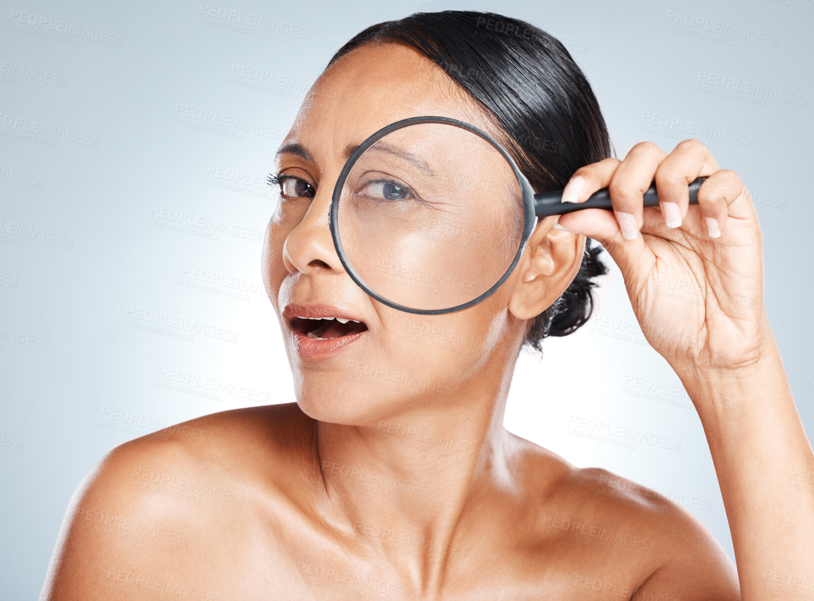Buy stock photo Magnifying glass, skincare and mature woman in a studio with a health, wellness and natural face routine. Beauty, cosmetic and portrait of a female with a lens for an anti aging facial treatment.