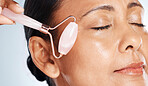 Face, mature woman with roller and massage closeup, antiaging skincare with beauty isolated on studio background. Facial, cosmetic tools and dermatology with natural cosmetics and skin wellness