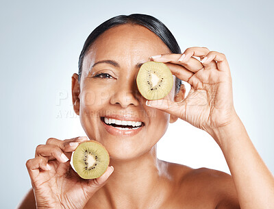 Buy stock photo Beauty, skin and kiwi, portrait of woman with smile on face for vitamin c facial detox and happy on studio background. Healthy skincare, wellness and sustainability in luxury cleaning fruit product.