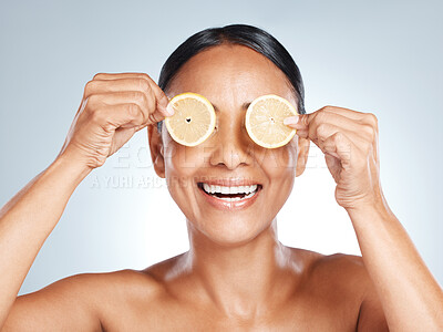 Buy stock photo Lemon, woman face and vitamin c skincare, beauty or clean wellness on studio background. Happy model, smile and citrus fruit of natural cosmetics, detox and facial nutrition of healthy aesthetic glow