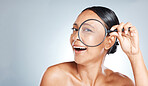 Magnifying glass, beauty and woman in a studio with a skincare, health and natural face routine. Beauty, cosmetic and portrait of a female with a lens for a wellness anti aging facial treatment.
