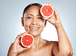 Grapefruit, portrait and vitamin c skincare of happy woman on studio background. Beauty model, face and citrus fruits for natural cosmetics, detox and nutrition benefits for healthy aesthetic results