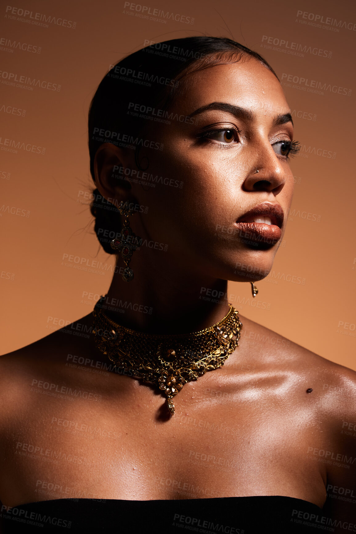 Buy stock photo Fashion, elegant and woman with jewellery in a studio with classy, fancy and stylish accessories. Luxury, beauty and female model with gold, vintage and retro jewelry isolated by a brown background.