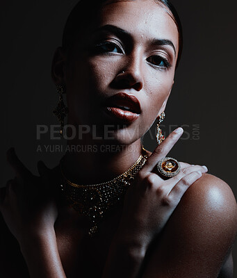 Beauty, jewelry and portrait of a woman with stylish accessories against a dark studio background. Female model with elegant, fancy and beautiful jewellery or style posing with cosmetic makeup