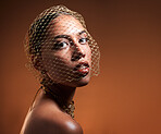 Vintage, fashionable and portrait of a woman with a net veil isolated on a brown background in studio. Fashion, stylish and face of a young retro model with a classy facial accessory on a backdrop