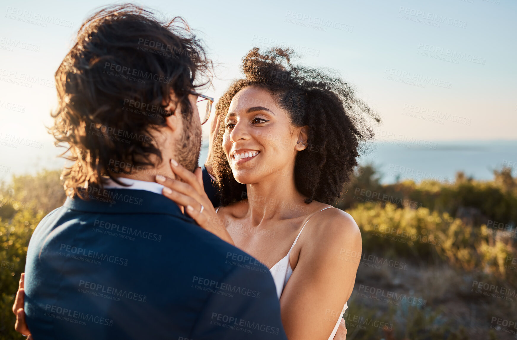 Buy stock photo Marriage, wedding and bride with groom on by ocean for ceremony, commitment and celebration of love. Romance, happiness and interracial couple bonding, hug and smile on mountain, nature and outdoors