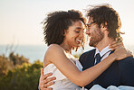 Marriage, interracial couple and love hug in nature of people happy about trust and commitment. Outdoor, sea and mock up at wedding with smile from bride and man in a suit at a partnership event