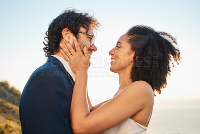 Buy stock photo Wedding, love and interracial couple on mountain for marriage ceremony, commitment and celebration by sea. Romantic holiday, happy and bride and groom bonding, hug and smile by ocean with sunset