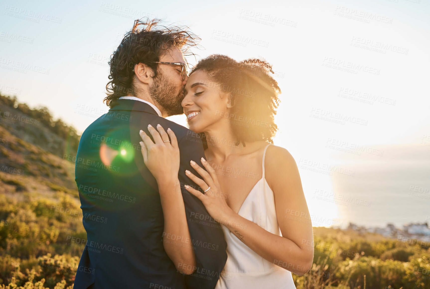 Buy stock photo Love, kiss and wedding with couple in nature for celebration, happiness and romance. Sunset, hug and affectionate with man and woman in embrace at countryside for happy, marriage and smile together