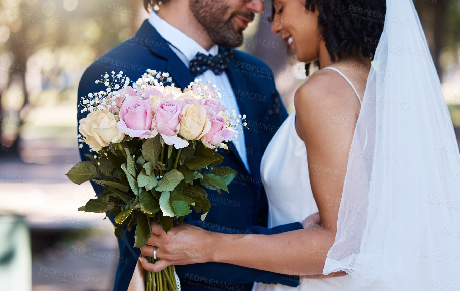 Buy stock photo Wedding, couple and hug with flower bouquet outdoor at marriage celebration event for bride and groom. Happy interracial man and woman at ceremony with trust, partnership and together for commitment