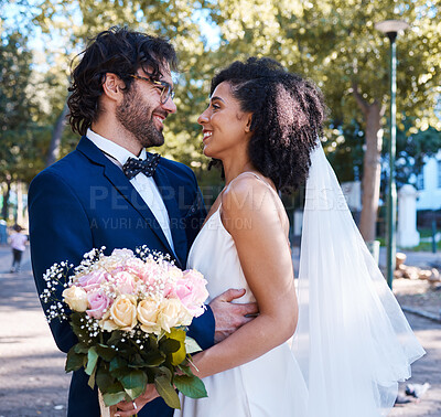 Buy stock photo Interracial wedding and couple with flowers and hug at romantic outdoor marriage event celebration together. Partnership, commitment and trust embrace of happy bride and groom with smile.