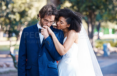 Buy stock photo Wedding, couple and kiss while holding hands outdoor at marriage celebration event together with commitment. Interracial man and woman with trust, partnership and respect or care in nature park