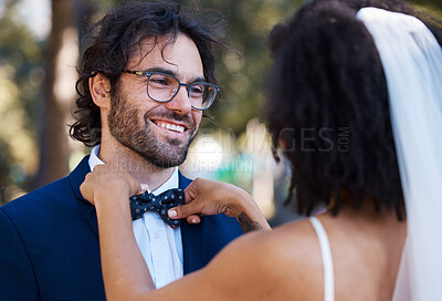 Buy stock photo Wedding, happy couple and bow tie outdoor at marriage celebration event together with care. Smile of groom and bride at a park with love, partnership and support or commitment while helping with suit