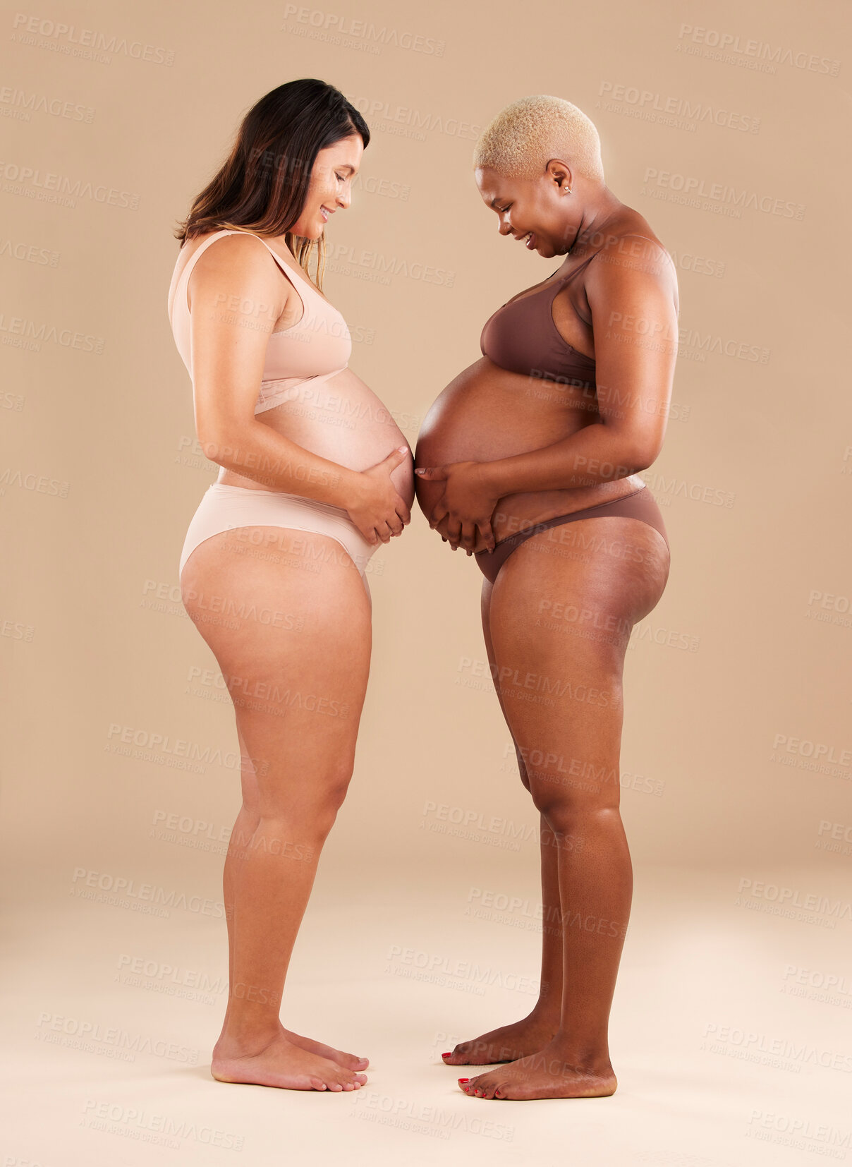 Buy stock photo Two women, pregnant and belly touch in studio for support, bonding and friends by background. Young future mother, pregnancy and happy with solidarity, diversity and care for wellness, health or hope