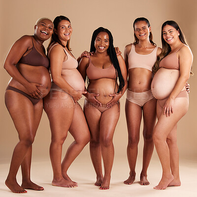 Buy stock photo Pregnancy, beauty and portrait of friends in a studio for diversity, motherhood and prenatal wellness. Maternity, love and pregnant women showing their baby bump stomach together by beige background.