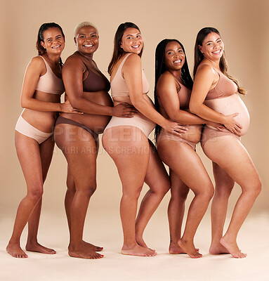 Buy stock photo Portrait, pregnant and happy women in row on studio background in community, diversity or baby support group. Smile, happy or bonding mothers with pregnancy stomach, underwear or healthcare wellness