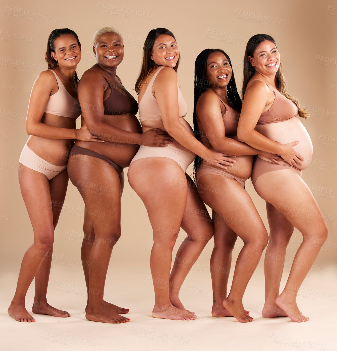 Buy stock photo Portrait, pregnant and happy women in row on studio background in community, diversity or baby support group. Smile, happy or bonding mothers with pregnancy stomach, underwear or healthcare wellness