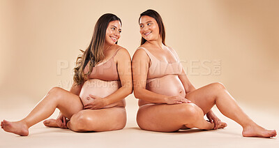 Buy stock photo Women, bonding or sitting with pregnant stomach, tummy growth progress or baby healthcare wellness on studio background. Smile, happy or friends in pregnancy underwear for solidarity support or love