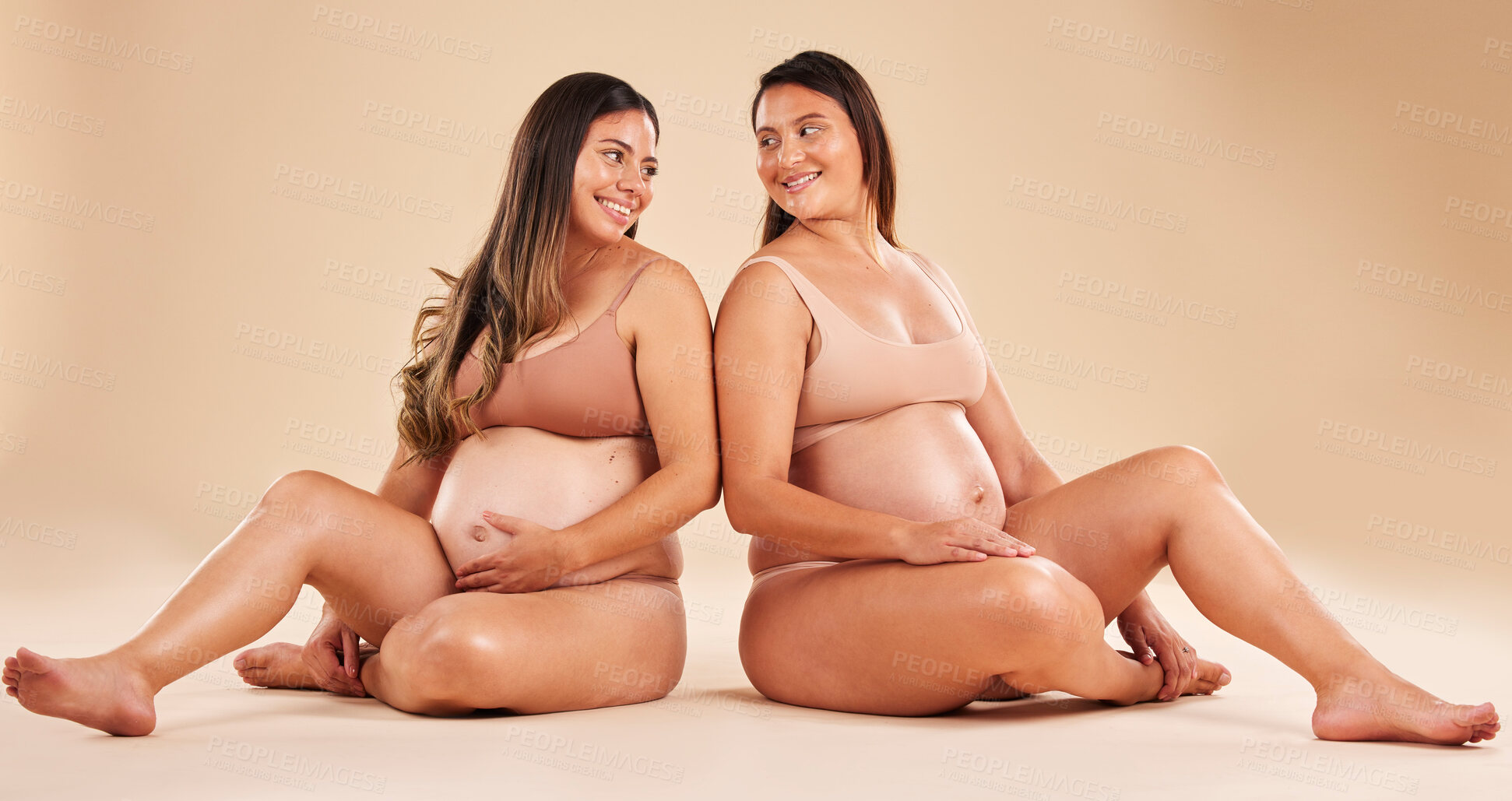 Buy stock photo Women, bonding or sitting with pregnant stomach, tummy growth progress or baby healthcare wellness on studio background. Smile, happy or friends in pregnancy underwear for solidarity support or love