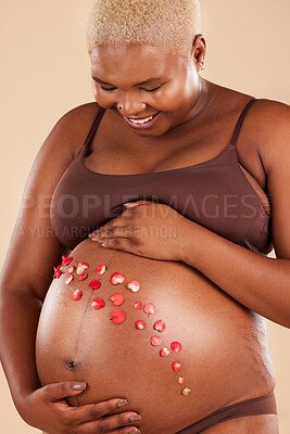 Buy stock photo Pregnant woman, smile and flowers on stomach in studio, body and baby wellness of ivf healthcare. Mother, pregnancy and floral plants on abdomen of happiness, beauty or excited for natural childbirth