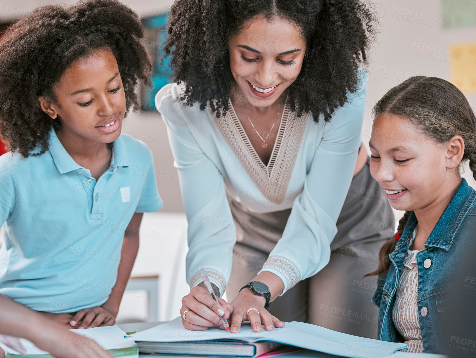 Buy stock photo Helping students with homework, female teacher in classroom with children listening and writing in book. Diversity in education, educator reading kids notebook and group learning literature together