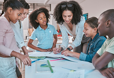 Buy stock photo Female teacher in classroom with students, helping learner with homework and writing in book. Children's education at school, educator reading kids notebook and group learning together for assessment