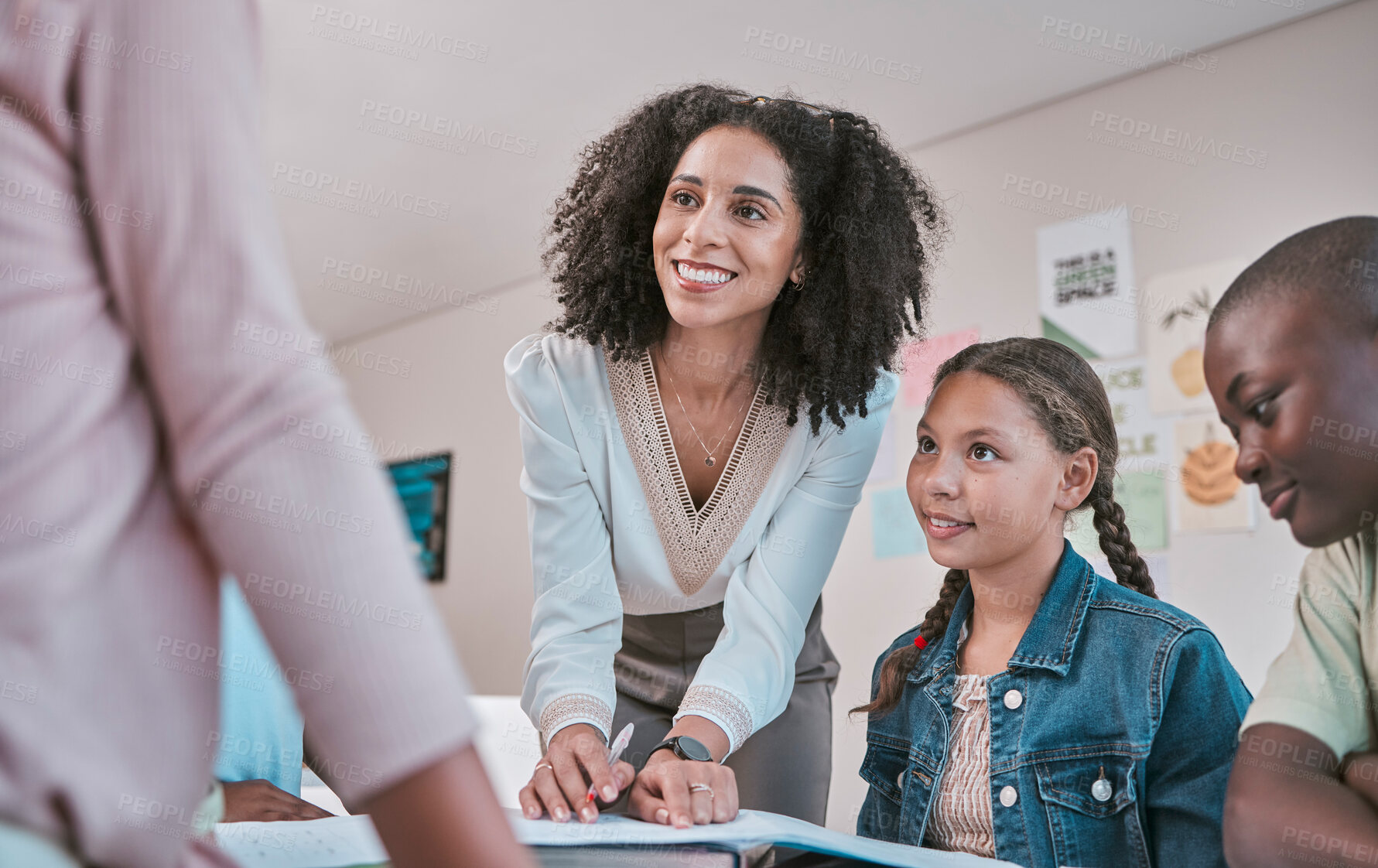 Buy stock photo Happy teacher in classroom with children, helping students with homework and writing in book. Education in school, female educator reading kids notebook and group learning together for assessment