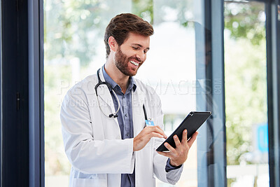 Buy stock photo Doctor, man and tablet for research at hospital for social media app, email and networking by window. Happy medic, communication or typing medical advice for help, consulting or chat on web at clinic