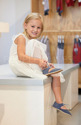 Buy stock photo Little girl, portrait smile and tying shoe lace on table in retail store for cute toddler fashion or style. Happy adorable child smiling for shopping, trying out or fitting on shoes at clothing shop