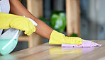 Woman cleaner, spray and cloth on table for hygiene, health or safety to stop bacteria in home for wellness. Spring cleaning expert, chemical liquid and fabric material in hands with service on desk