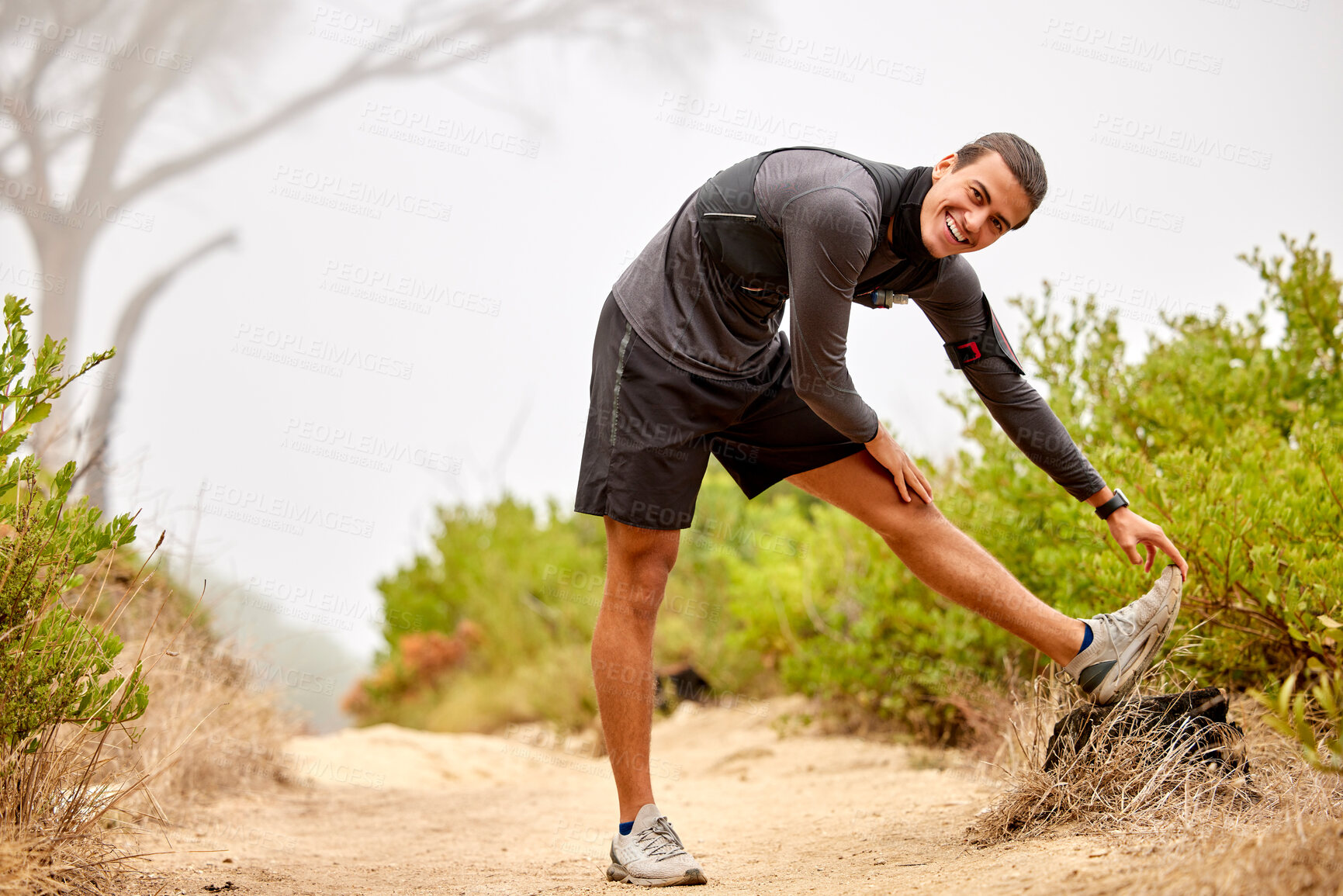 Buy stock photo Fitness, stretching legs and portrait of man on nature trail for running, marathon training and cardio workout. Sports, healthy body and happy male athlete warm up for wellness, exercise and hiking