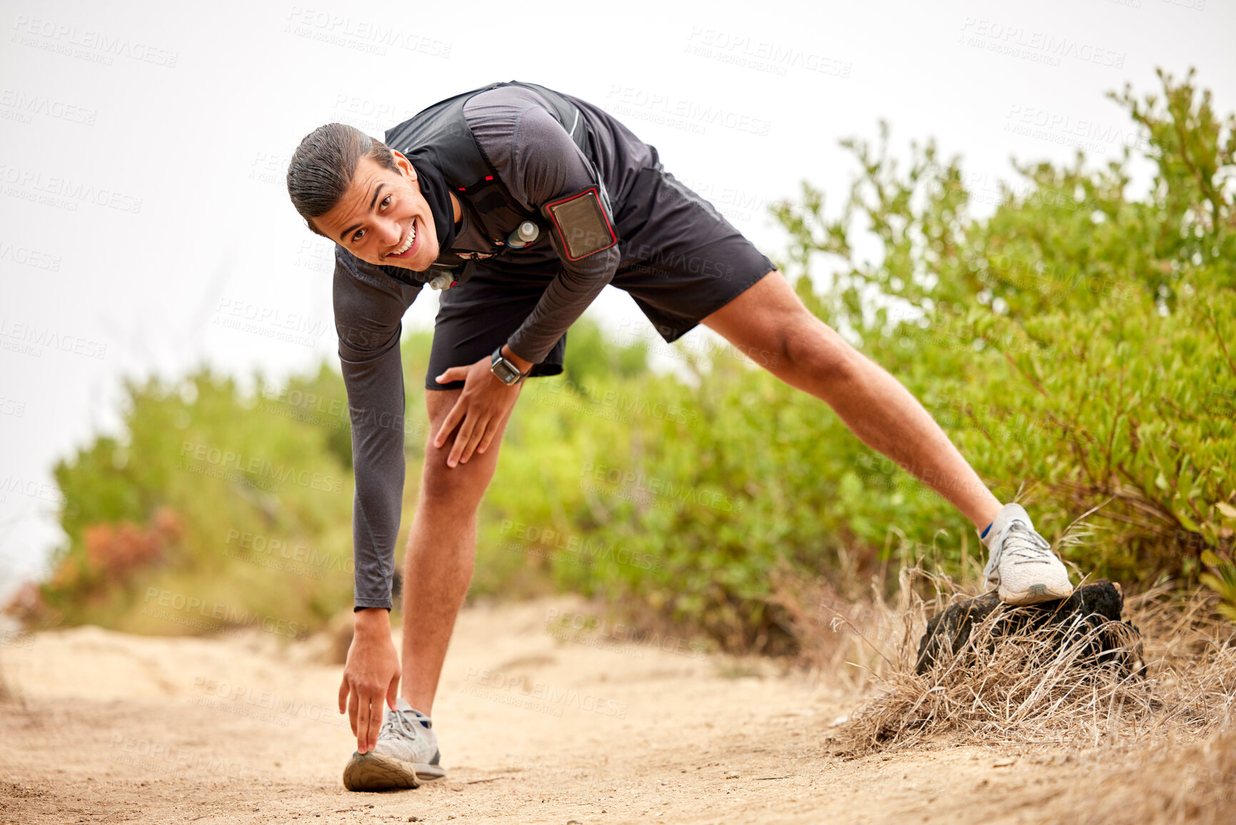 Buy stock photo Stretching legs, exercise and man on nature trail for running, marathon training and cardio workout. Sports, healthy body and portrait of happy male athlete warm up for wellness, exercise and balance