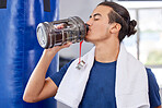 Fitness, man and drinking water in gym for health, rest and energy for boxing, workout and towel. Thirsty sports person, bodybuilder and athlete hydration, bottle and exercise nutrition for wellness