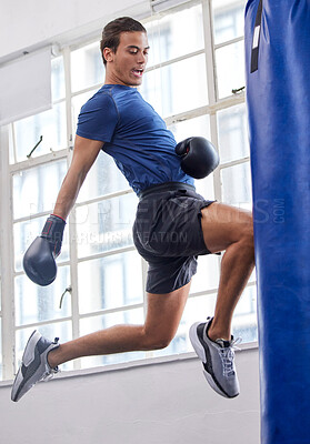 Buy stock photo Gym, jump and kick of boxer man for sports workout, training and athlete practice with equipment. Energy, focus and strength of martial arts fighter at kickboxing fitness club with punching bag.