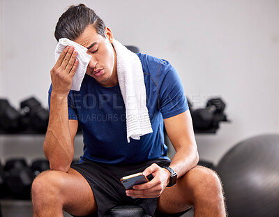 Buy stock photo Sweat, tired and man resting in the gym after a intense workout, exercise sports training. Fitness, sport and male athlete networking on social media with a phone after exercising in wellness studio.